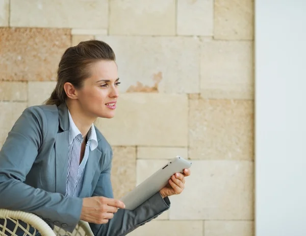 Thoughtful business woman holding tablet PC and looking on copy