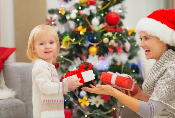 Mother and baby girl changing Christmas presents