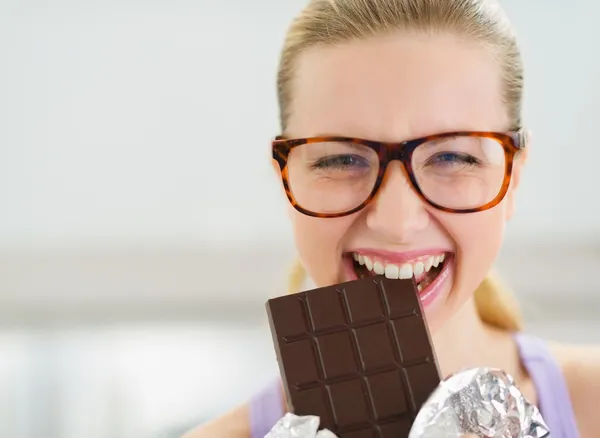 Happy teenage girl eating chocolate bar