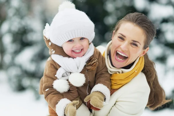 Portrait of happy mother and baby in winter park