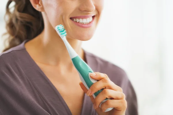 Closeup on young woman with toothbrush