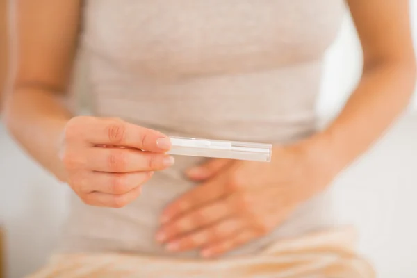 Young woman holding pregnancy test