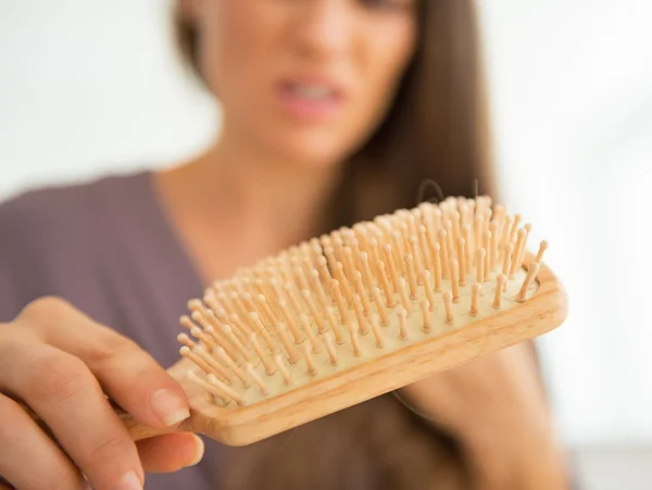 Woman looking on hair comb