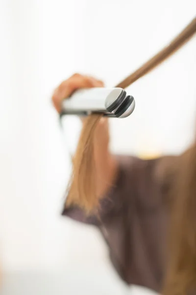 Woman using hair straightener