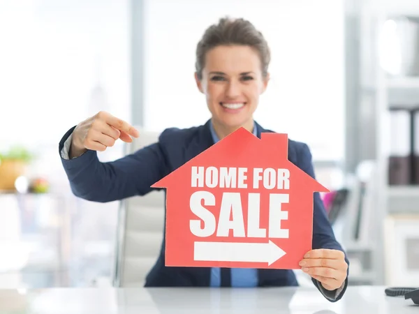 Realtor woman pointing on sign