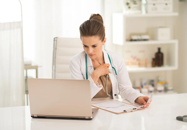 Thoughtful doctor looking in laptop