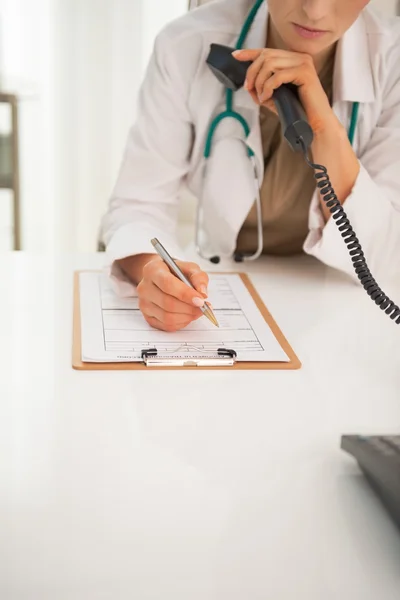 Medical doctor woman with phone writing