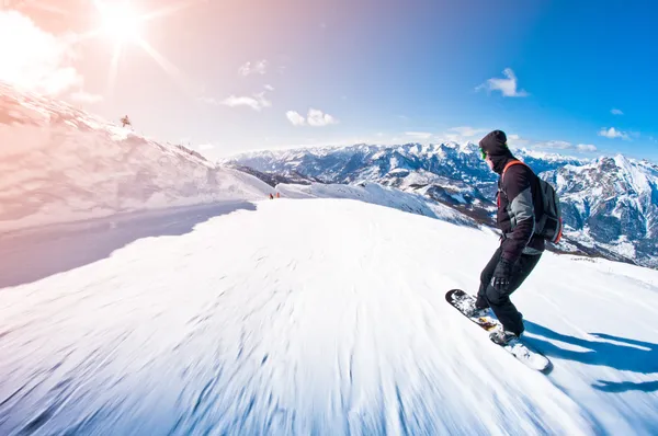 Snowboarder riding fast, motion blur, fisheye shot