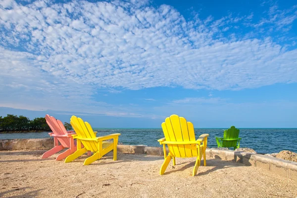 Summer scene with colorful lounge chairs at a tropical beach in Florida with blue sky and ocean