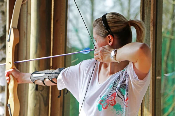 Woman shooting with a bow and arrows