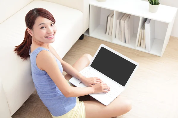 Woman using laptop on sofa