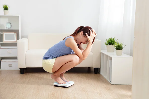 Upset woman on weigh scale