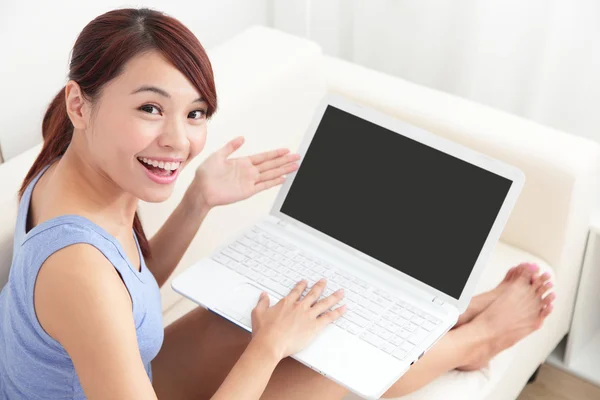 Woman using laptop on sofa