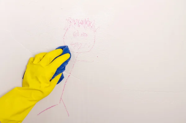 Cleaning crayon off wall with cloth