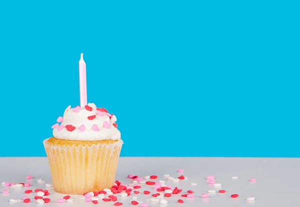 Cupcake with pink candle and heart sprinkles