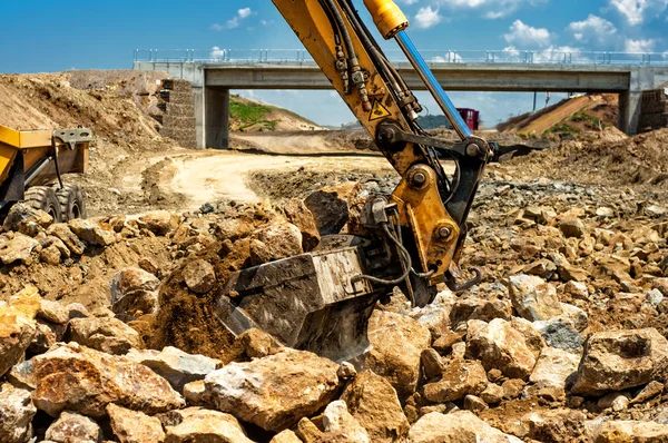 Dumper truck loading rocks and sand on construction site