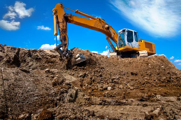 Industrial excavator bulldozer in sandpit with raised bucket