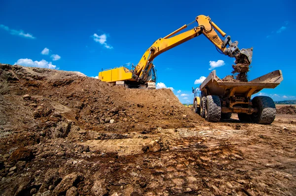 Industrial excavator loading and moving soil material