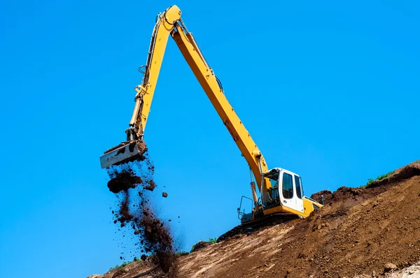 Industrial excavator loading soil material from highway