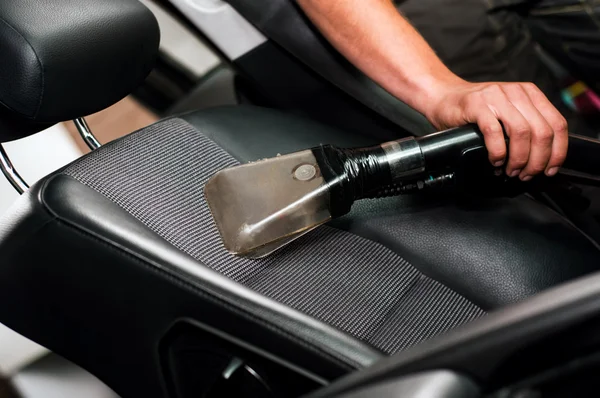 Auto car service cleaning the drivers seat, cleaning and vacuuming leather