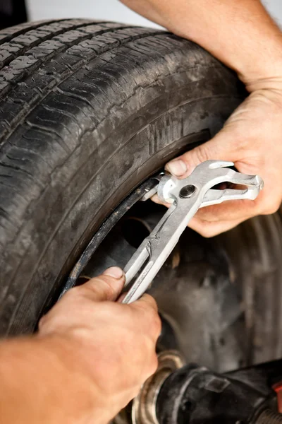 Old-school mechanic manually adjusting rim thickness with tools