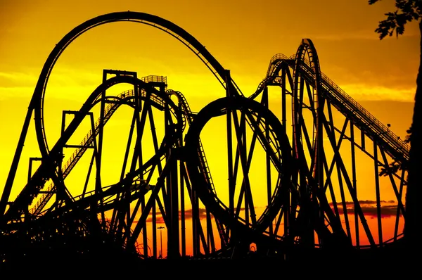 Silhouette of a roller coaster at sunset, after a sunny day at fair isolated on yellow background