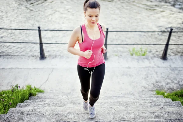 Female athlete jogging and training on street, stairs and urban city park. Urban city fitness concept