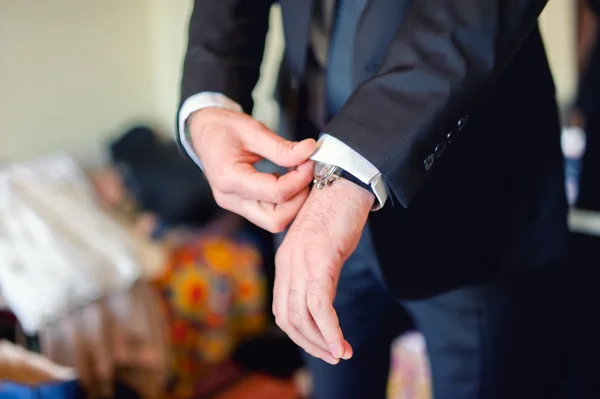 Close up of elegant man, groom hands with suits, ring, necktie and cufflinks on wedding day