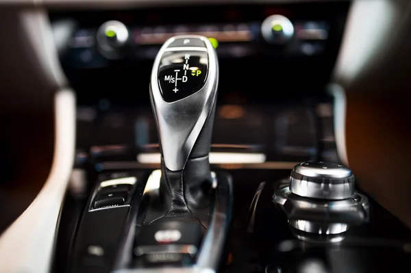 Detail of an automatic gear shifter in a new, modern car. Modern car interior with close-up of automatic transmission and cockpit background