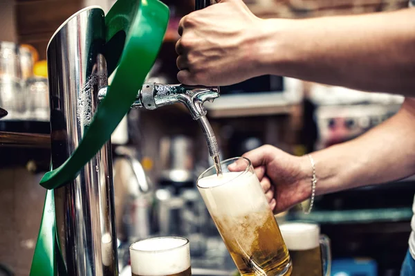 Barman pouring or brewing a draught beer at restaurant, bar or pub