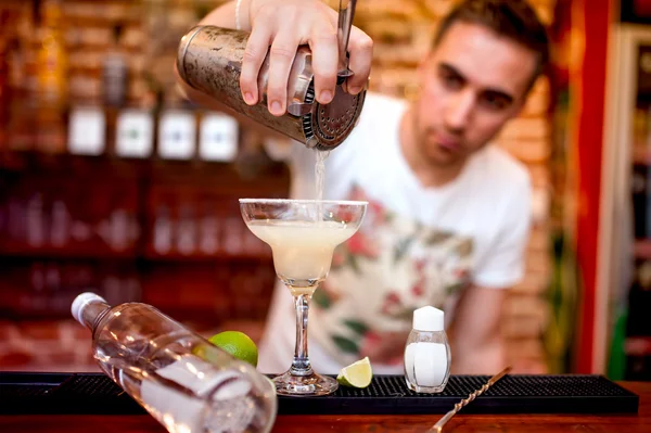 Barman pouring a margarita alcoholic cocktail served in casino and bar