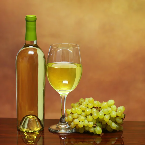 Wine Bottle and Glass of White Wine with Fresh Grapes