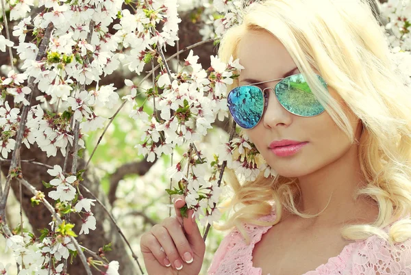 Blonde Girl with Aviator Sunglasses over Cherry Blossom. Spring