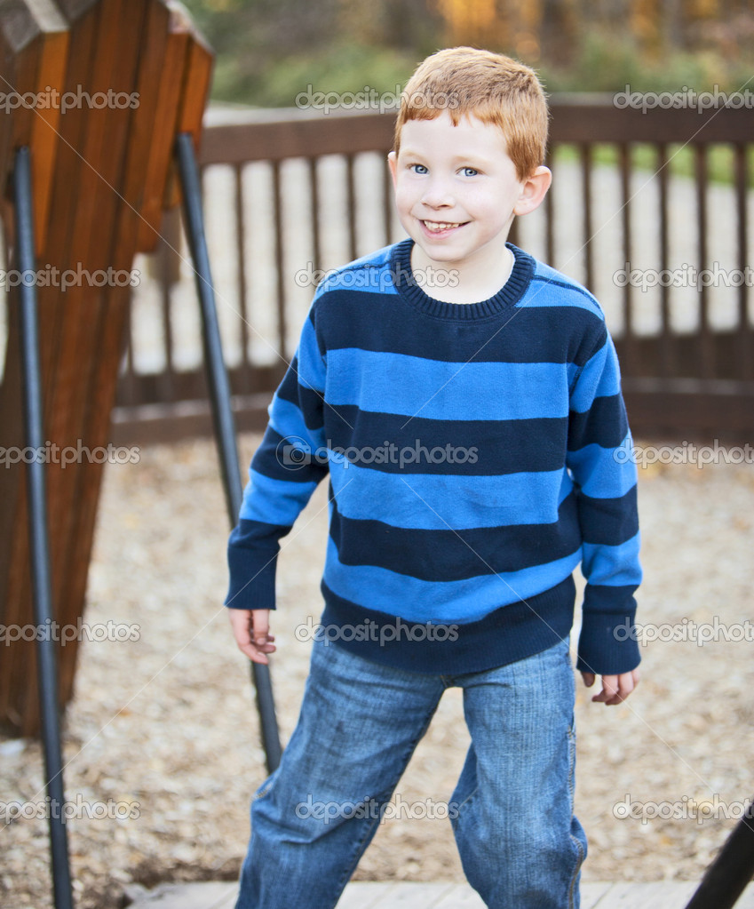 Young ginger boy playing in the playground — Stock Photo © ericro 37300939