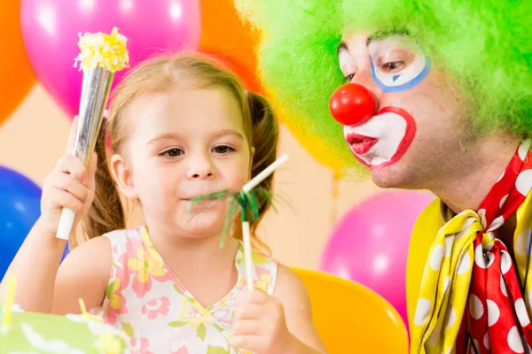 Happy child girl with clown on birthday party