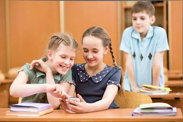 School kids with cell phones in classroom — Stock Photo #31995557