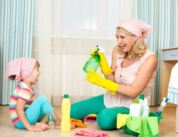 Mother with kid cleaning room and having fun