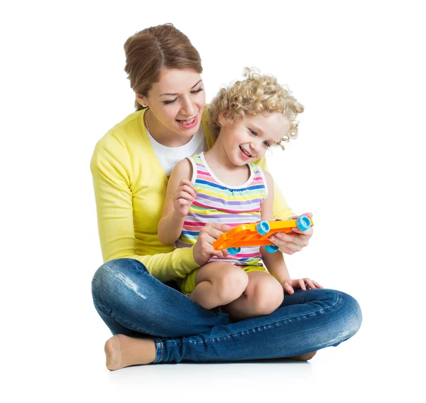 Mother and kid girl having fun with musical toy. Isolated on whi