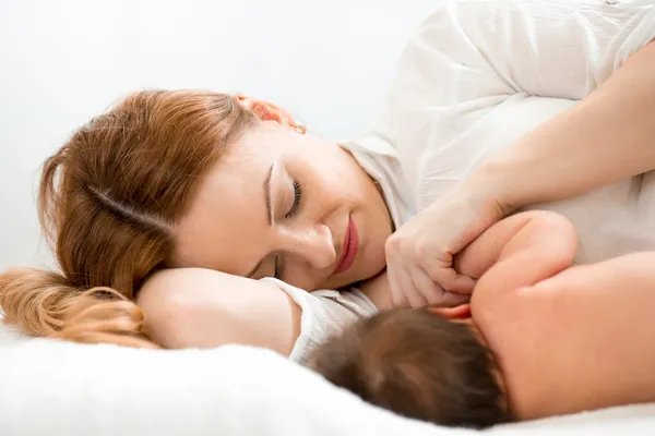 Happy mom breast feeding newborn baby