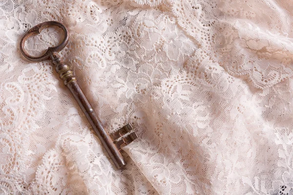 Old key on lace fabric