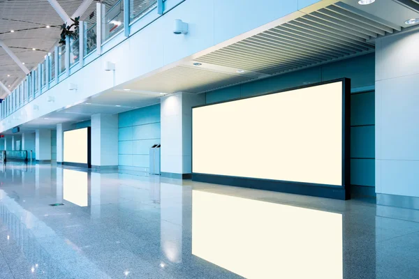 Airport passengers and blank billboard