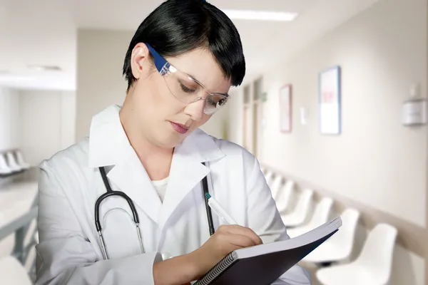 Thoughtful brunette female doctor on duty at the ER lobby taking