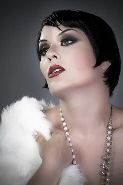 Gourgeos brunette flapper wearing pearls and fur