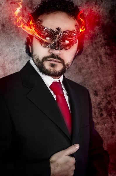 Evil man with fiery eyes and Venetian mask