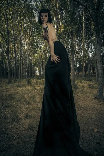 Gothic woman in dark forest, fantasy concept, dark queen