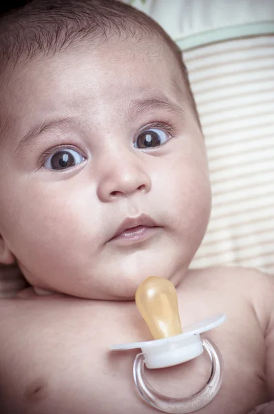 Pacifier, new born baby curled up sleeping on a blanket