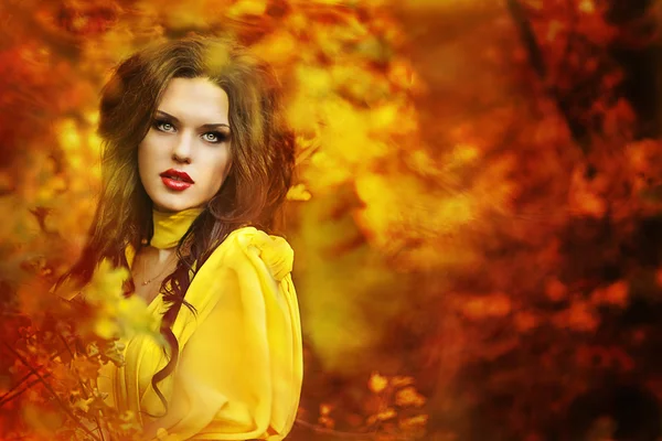 Beautiful girl in a yellow dress walking the air in the forest