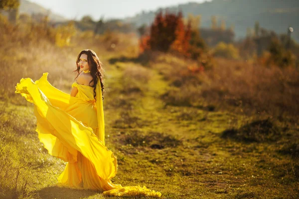 Beautiful girl in a yellow dress air