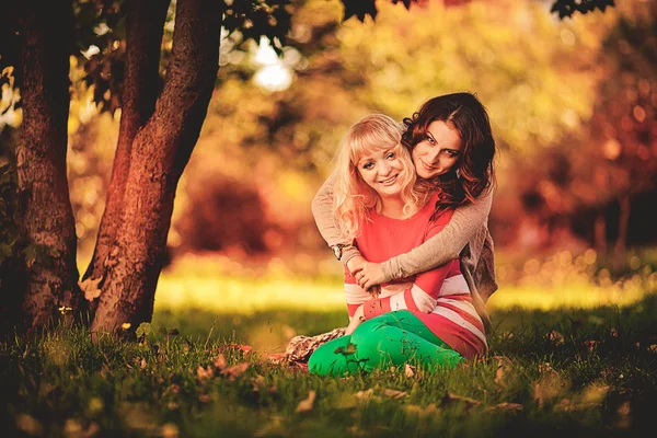 Two girlfriends in the park in autumn