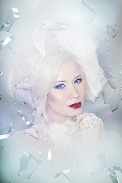 Winter Woman Portrait. Snow. Beauty Fashion Model Girl with White Hair and Blue Eyes closeup.